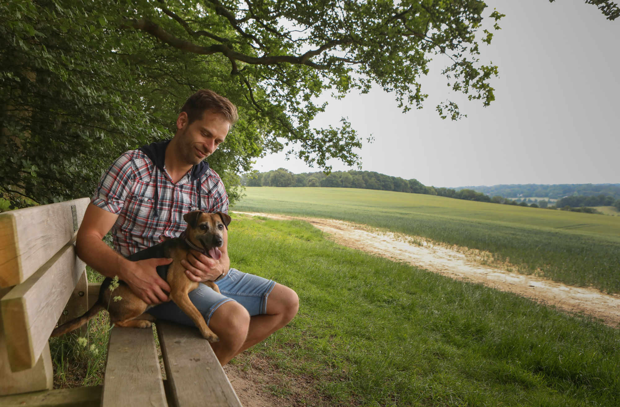 Jonathan and Penny, his dog sat on a bench overlooking rolling fields