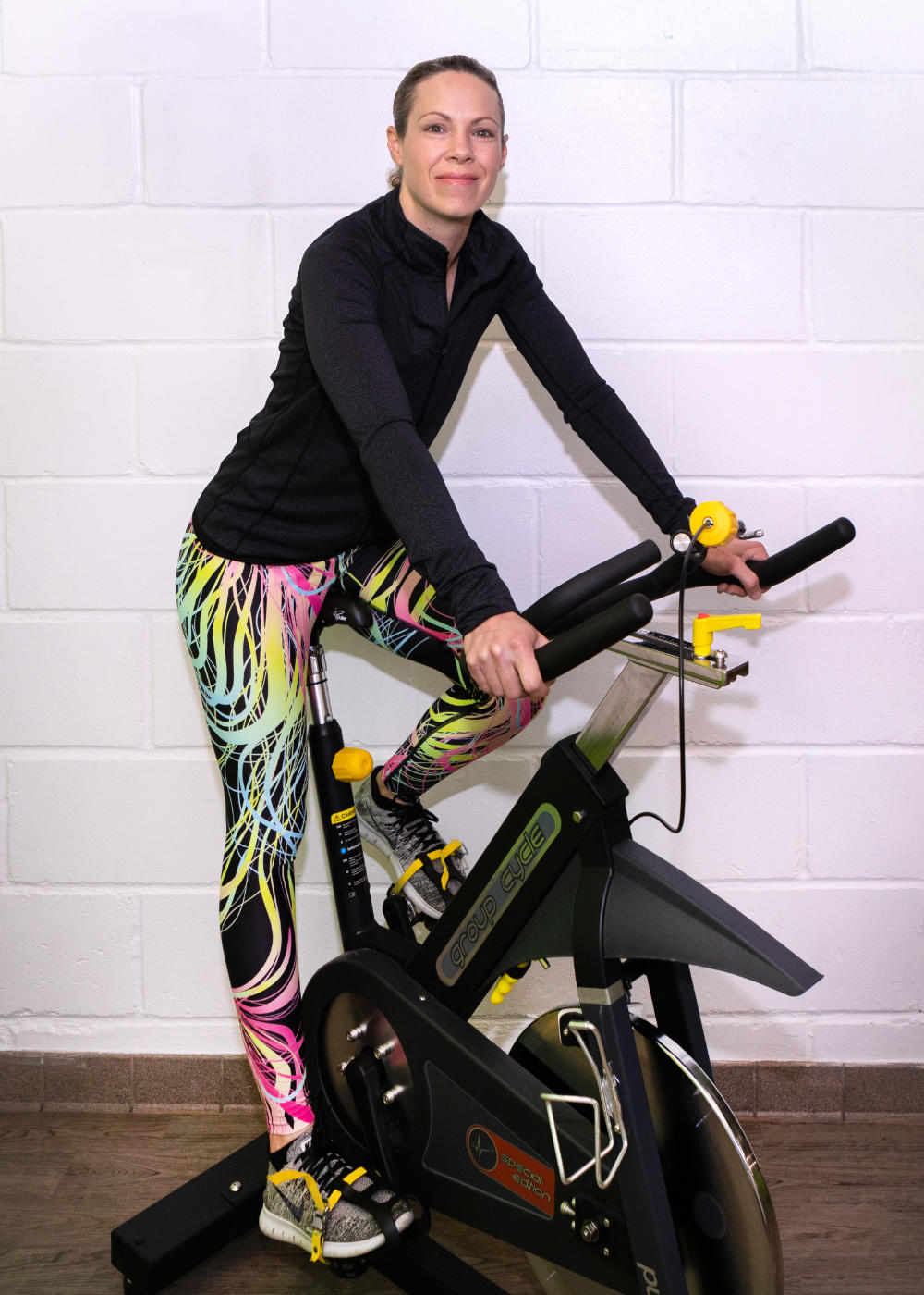 Taryn smiling whilst sat on a stationary exercise bike